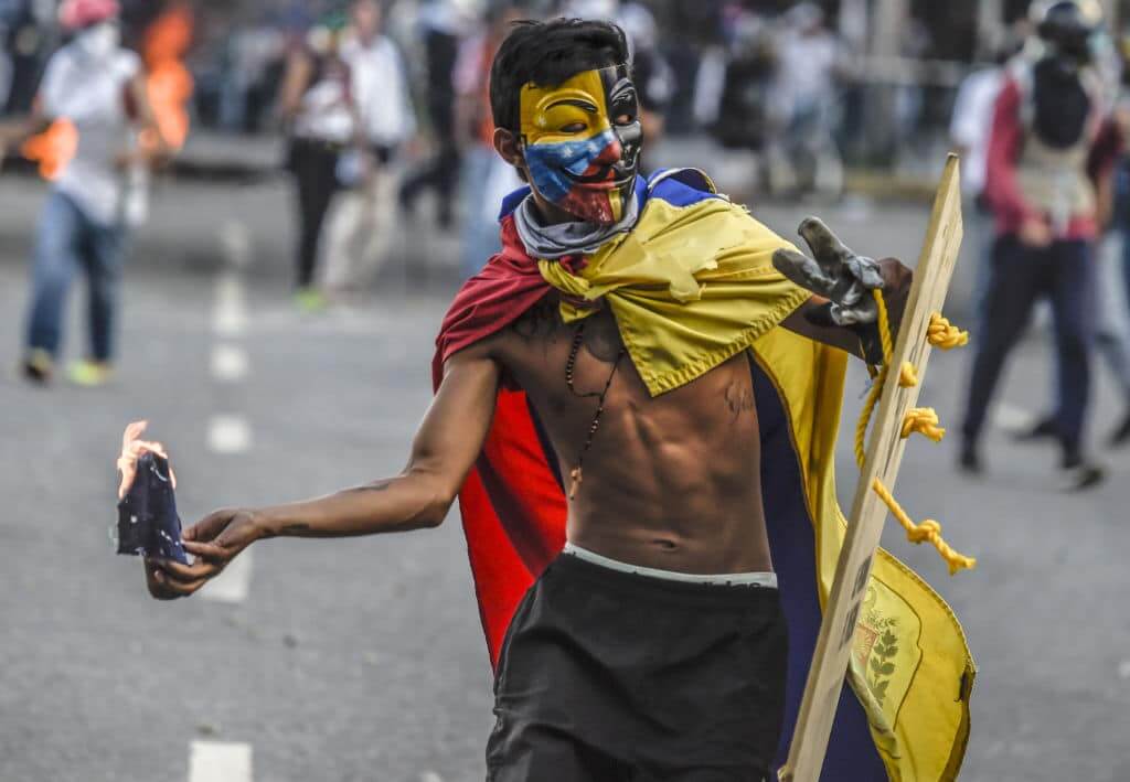 Opposition demonstrators and riot police clash during a protest against President Nicolas Maduro in Caracas, on July 6, 2017. A political and economic crisis in the oil-producing country has spawned often violent demonstrations by protesters demanding Maduro's resignation and new elections. The unrest has left 91 people dead since April 1. 